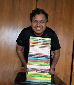 Devdutt Pattanaik, mythologist and author, with books written by him.