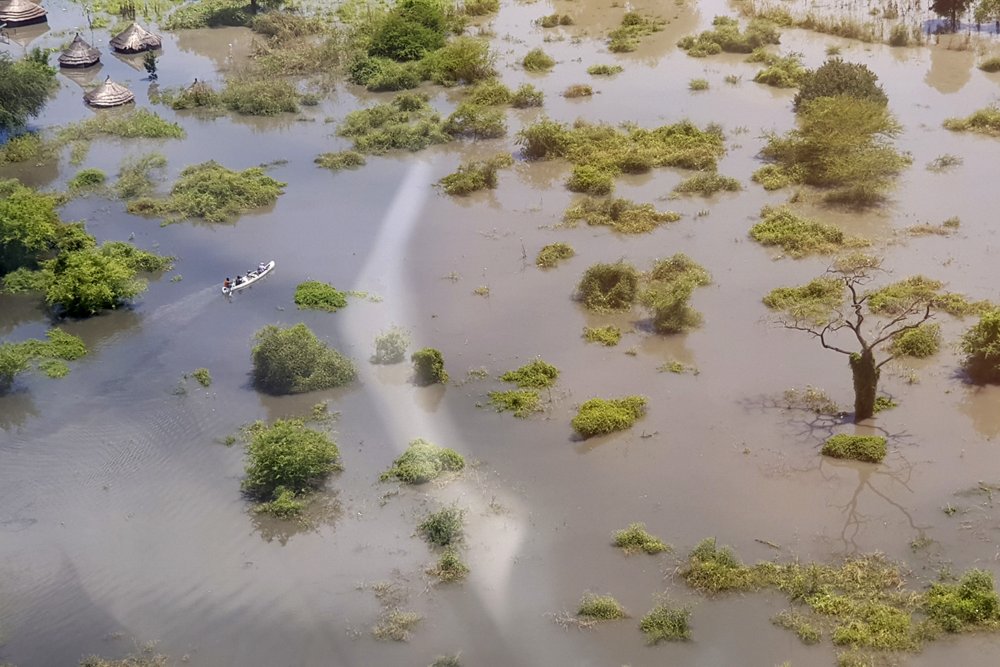 In this photo taken Saturday, Oct. 19, 2019 and released by Medecins Sans Frontieres, people in a canoe move through floodwaters between Gumuruk and Lekongole, seen from the air, in South Sudan. South Sudan's president on Tuesday, Oct. 29, 2019 declared a state of emergency in 27 counties because of the flooding and parts of the East African region are bracing for a tropical storm that could worsen an already dire humanitarian situation. (Medecins Sans Frontieres via AP)
