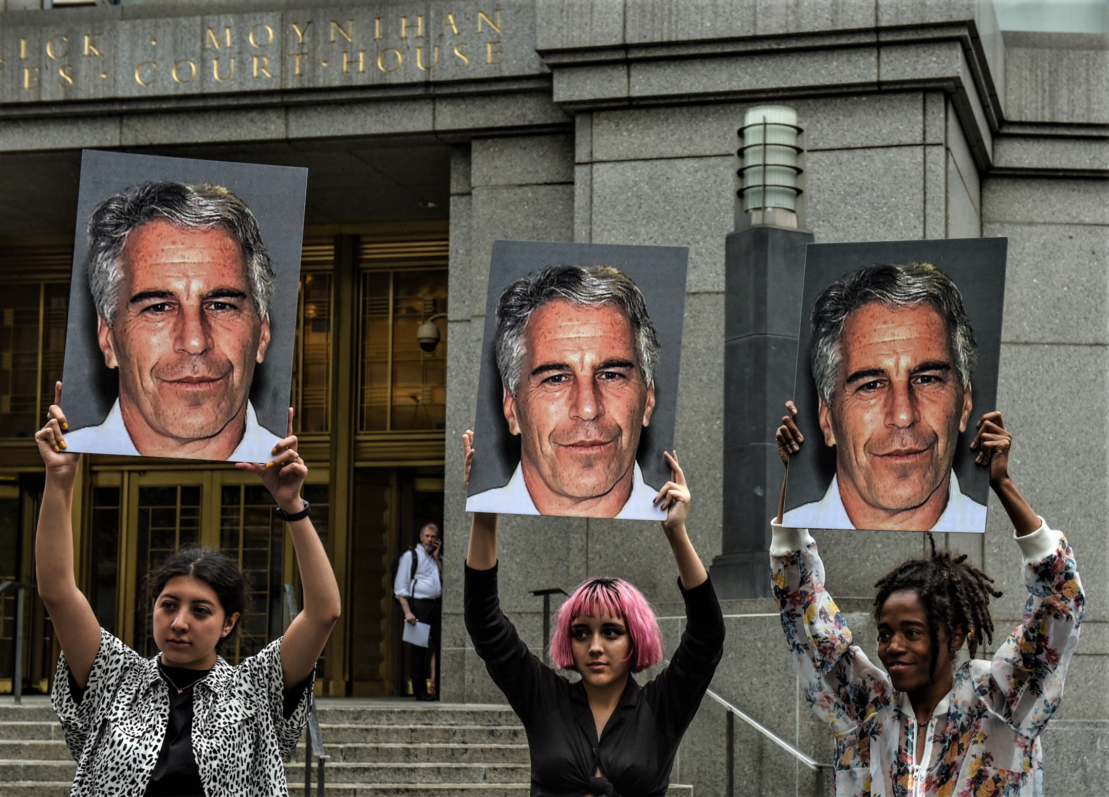 A protest group called "Hot Mess" hold up signs of Jeffrey Epstein in front of the Federal courthouse on July 8, 2019 in New York City. (Image by Stephanie Keith/Getty Images)