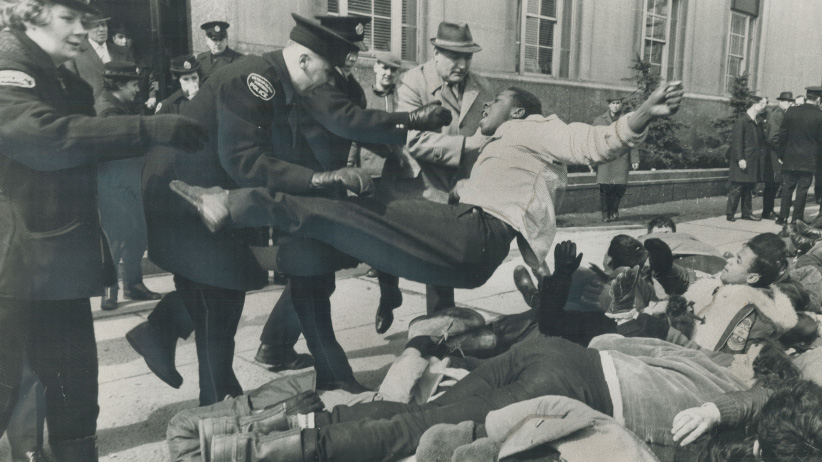 Police force a black youth to the ground. He was among about 80 student demonstrators who marched on the U.S. consulate on University Ave. to back civil rights workers in Alabama on March 16, 1966. (Gerry Barker/Toronto Star/Getty Images)