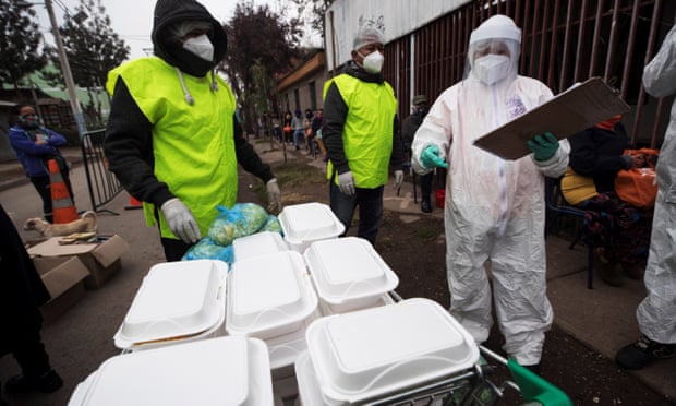 Workers prepare and deliver food for people affected by the coronavirus pandemic, in Santiago, Chile. (Image, Alberto Valdés/EPA)