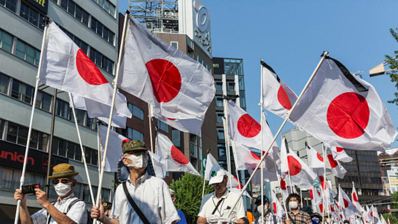 Demonstrators hold Japanese national flags as they march during a protest in support of the Yasukuni Shrine on August 15, 2020 in Tokyo, Japan. (Image by Yuichi Yamazaki/Getty Images News/Getty Images)