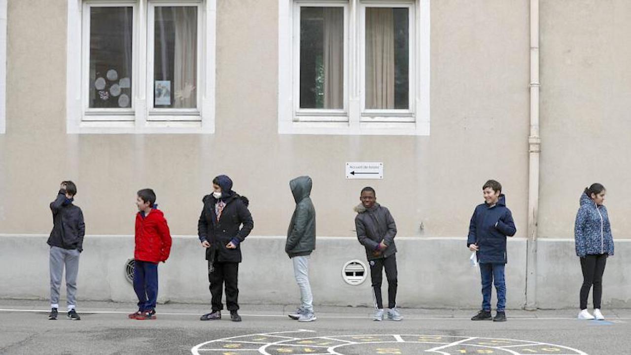 In this Thursday, May 14, 2020 file photo, schoolchildren wait in line to go back in their classroom at the Sainte Aurelie primary school of Strasbourg. (Image by Jean-Francois Badias)