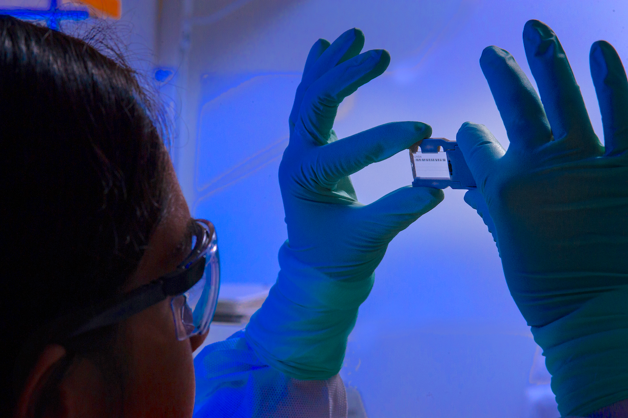 This photograph depicted an Enteric Diseases Laboratory Branch (EDLB) public health scientist, holding up a glass slide used for a run on a sequencing machine (Image by James Gathany/CDC)