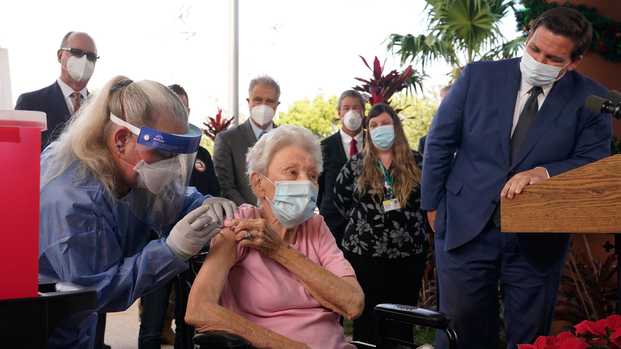 Florida Gov. Ron DeSantis watches as nurse Christine Philips, left, administers the Pfizer-BioNTech vaccine for COVID-19 to Vera Leip, 88, a resident of John Knox Village, Wednesday, Dec. 16, 2020, in Pompano Beach, Fla. Nursing home residents and health care workers in Florida began receiving the vaccine this week. (AP Photo/Marta Lavandier)