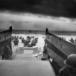 A LCVP (Landing Craft, Vehicle, Personnel) from the U.S. Coast Guard-manned USS Samuel Chase disembarks troops of Company A, 16th Infantry, 1st Infantry Division (the Big Red One) wading onto the Fox Green section of Omaha Beach (Calvados, Basse-Normandie, France) on the morning of June 6, 1944. American soldiers encountered the newly formed German 352nd Division when landing. During the initial landing two-thirds of Company E became casualties.