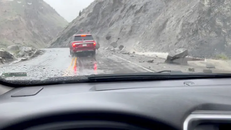 A view shows rocks sliding down the side of a hill and hitting a car at the North Entrance of Yellowstone National Park in Gardiner, Montana, U.S. June 12, 2022 in this still image obtained from a social media video released on June 14, 2022. (Image Anne Leppold/Reuters)