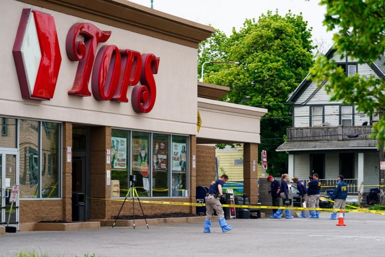 FILE - Investigators work the scene after a mass shooting at a supermarket, in Buffalo, N.Y., May 16, 2022. A white 18-year-old entered the supermarket with the goal of killing as many Black patrons as possible and gunned down 10. That shooter claims to have been introduced to neo-Nazi websites and a livestream of the 2019 Christchurch, New Zealand mosque shootings on the anonymous, online messaging board 4Chan. (AP Photo/Matt Rourke, File)